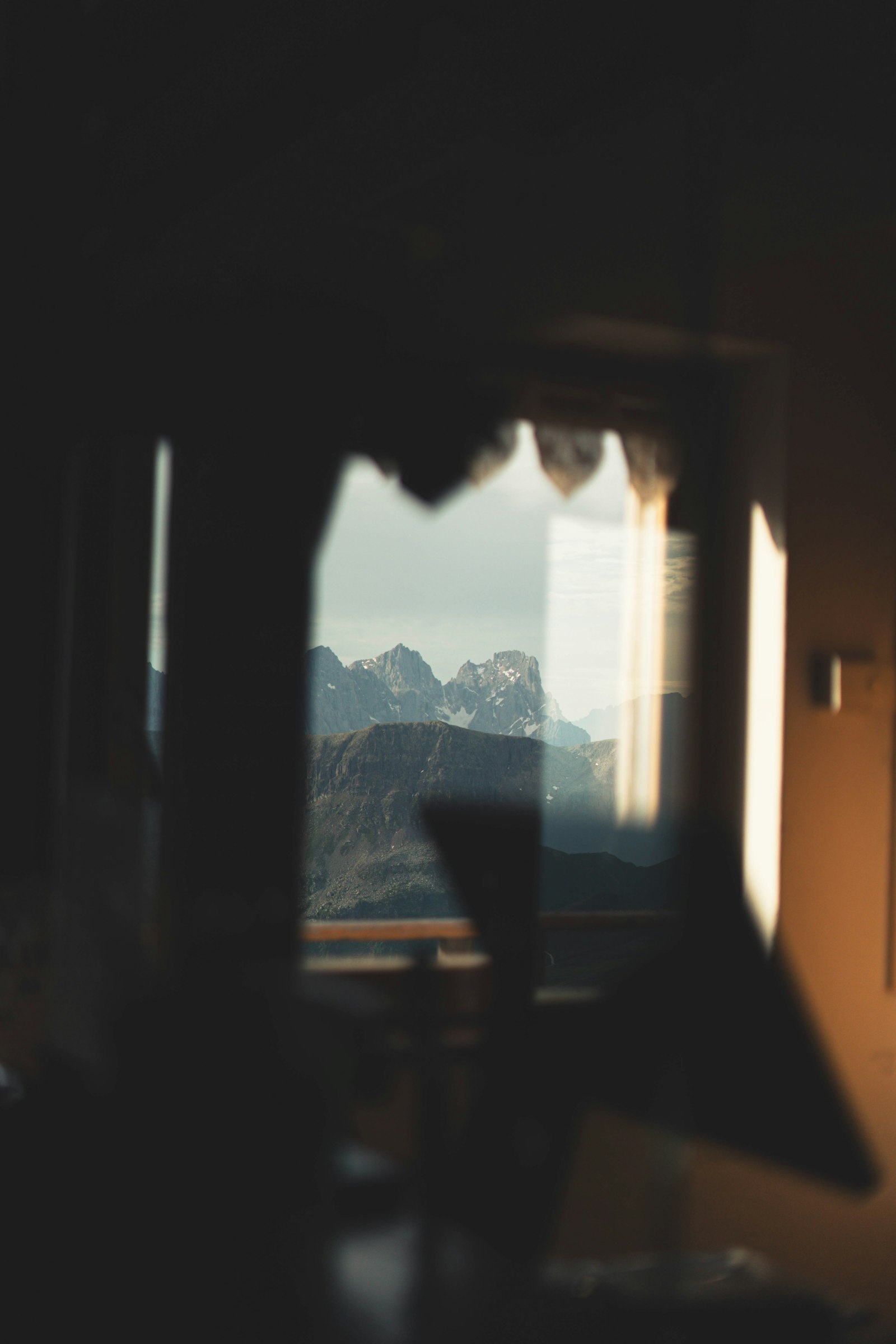 Mountain peaks seen through the bright window of a dark room